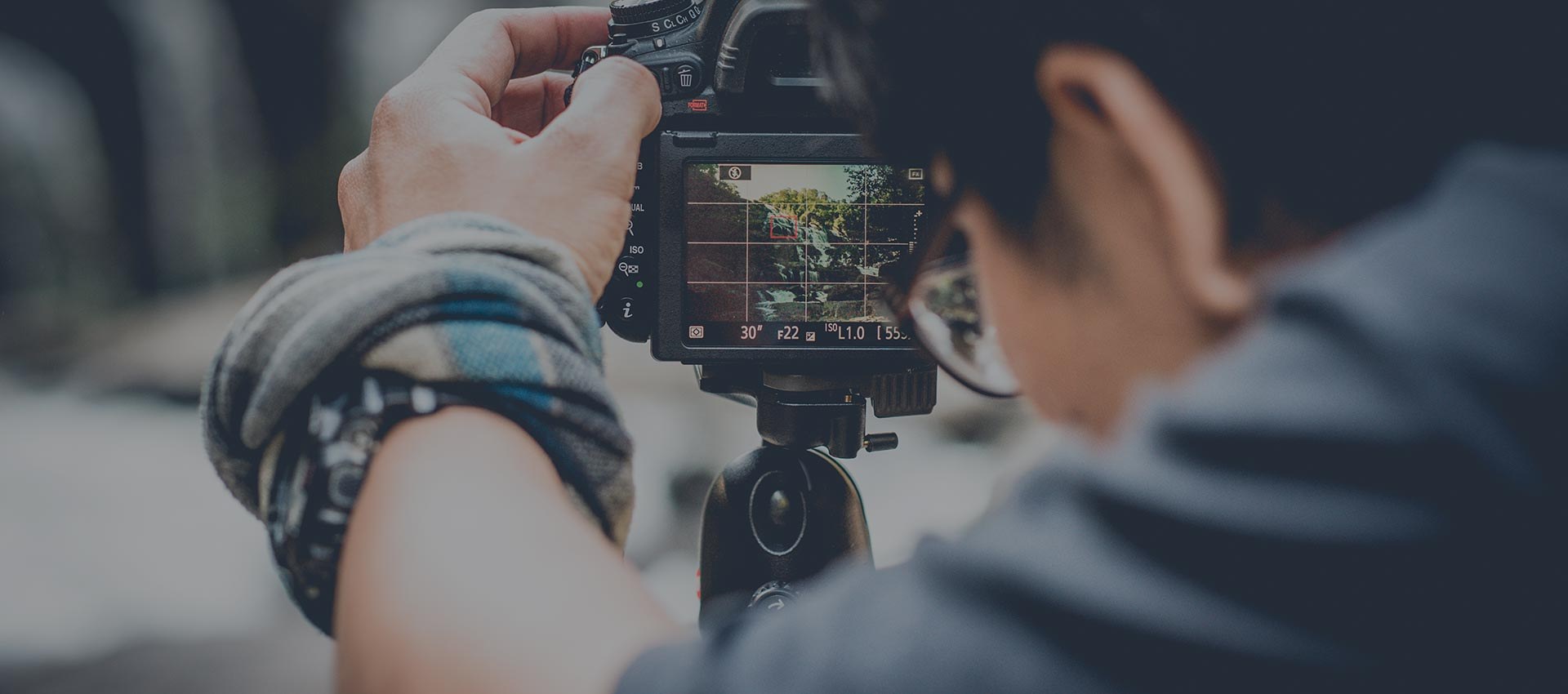 The photographer framing a facade on the camera's screen