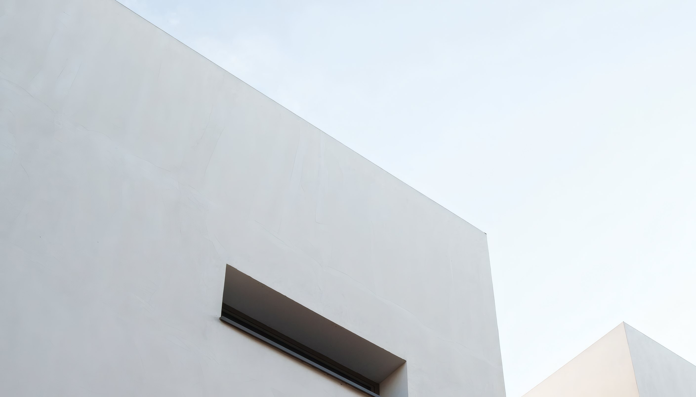 Lantern House by Casa Pala, a white wall with a slot window