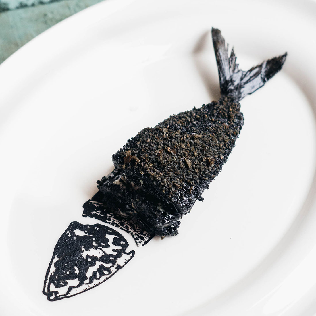 Squid ink cod on a white plate
