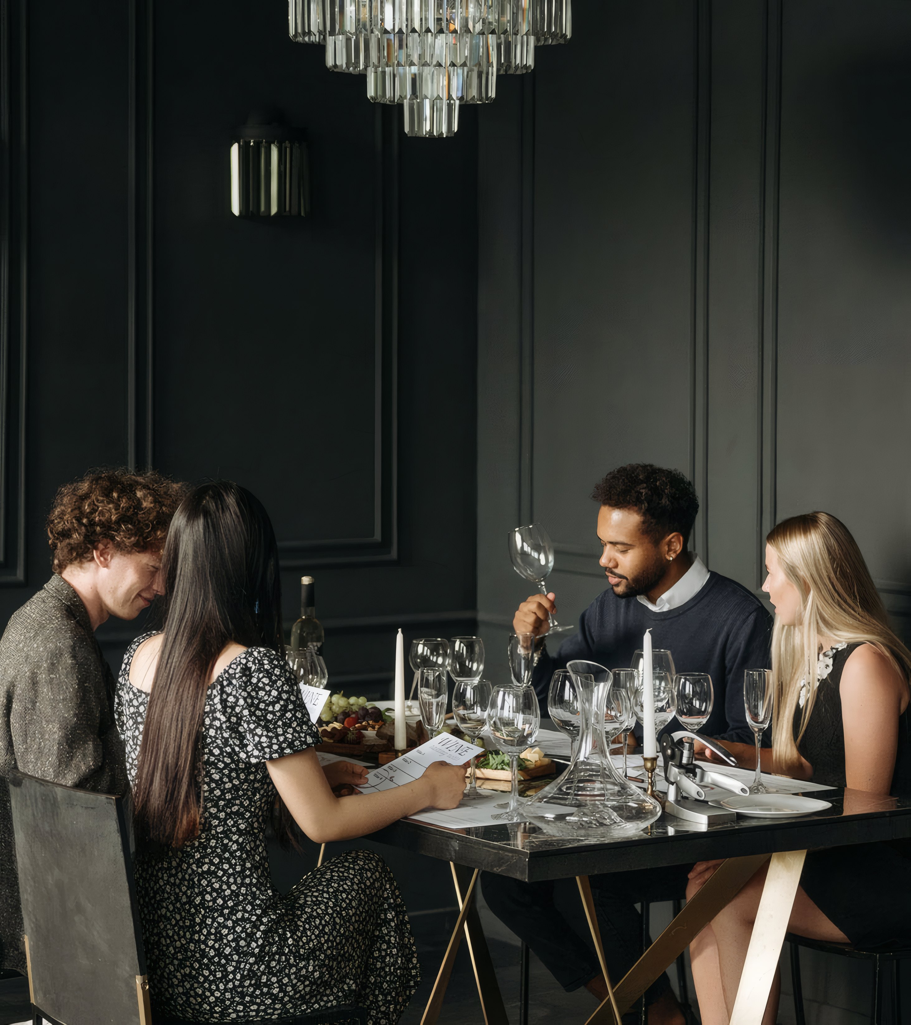Four friends at dinner in a dark panelled dining room