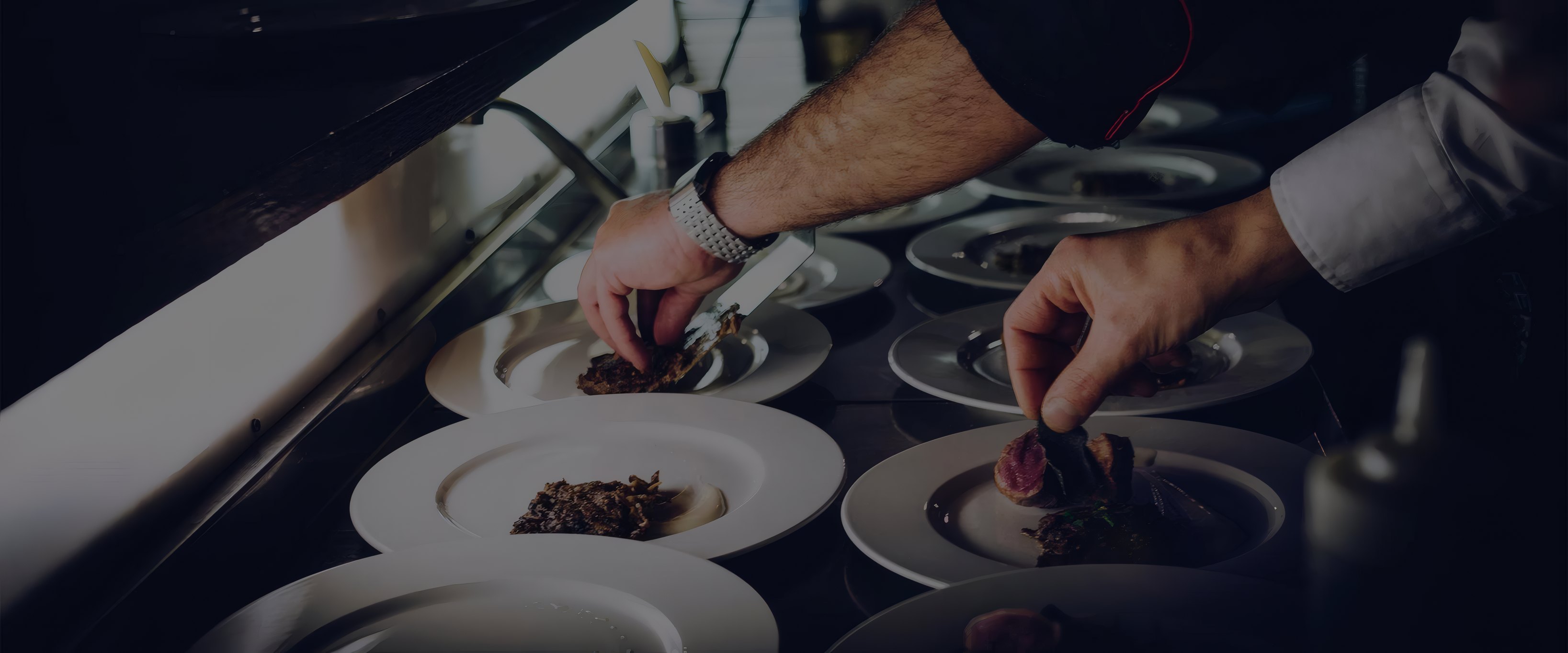 Chefs plating dishes at the pass