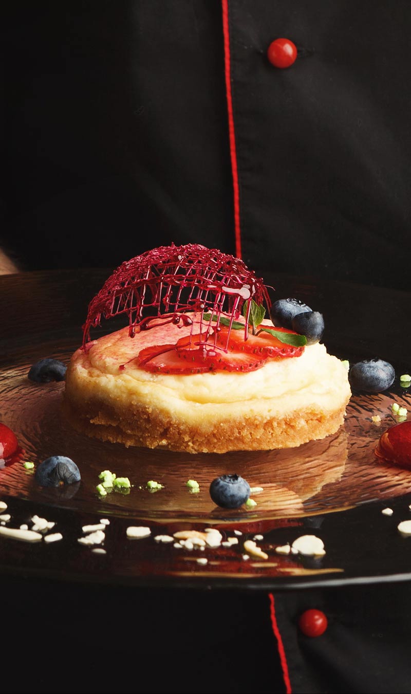 A chef presenting a plated dessert