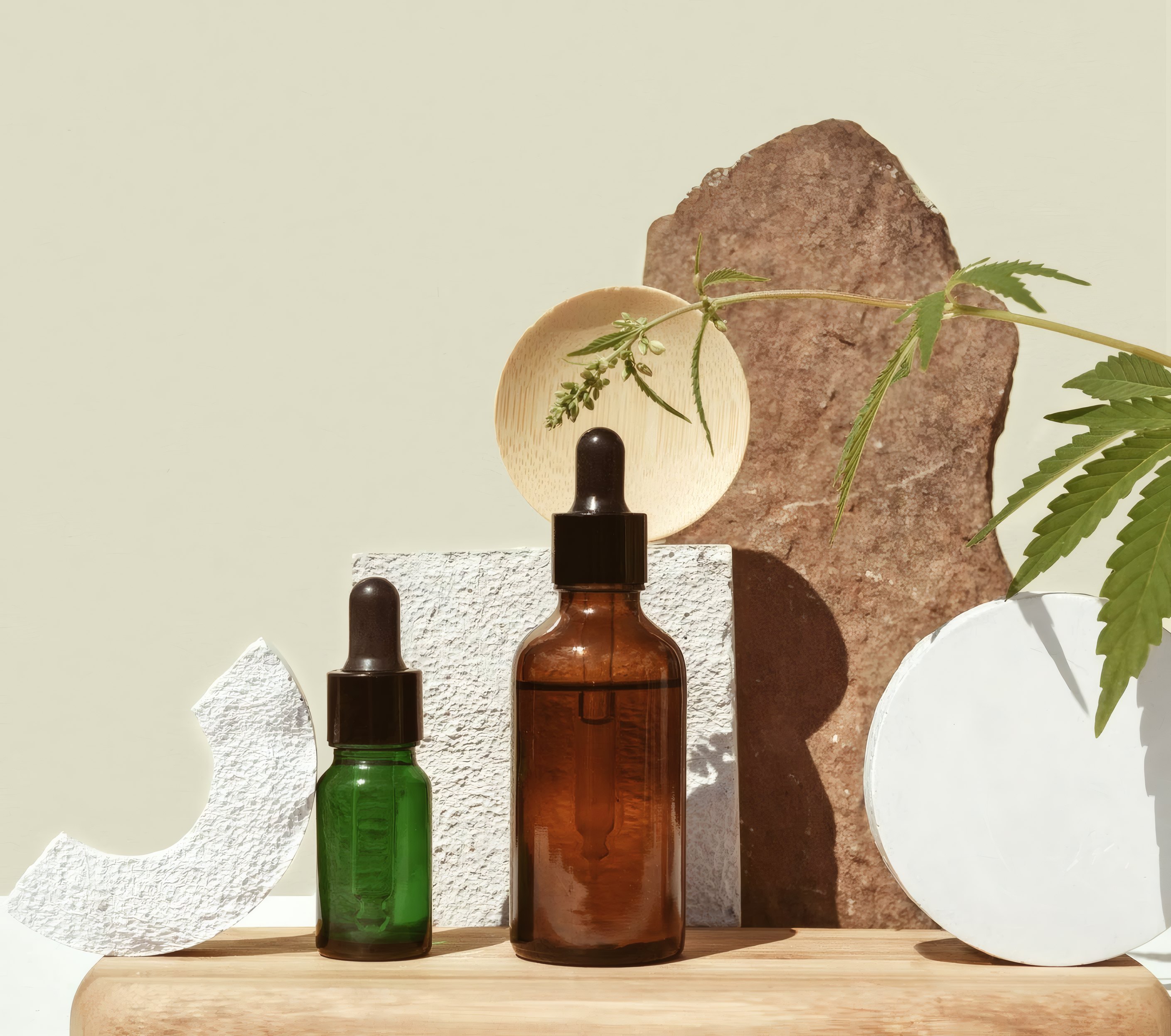Dropper bottles on stone with hemp leaves