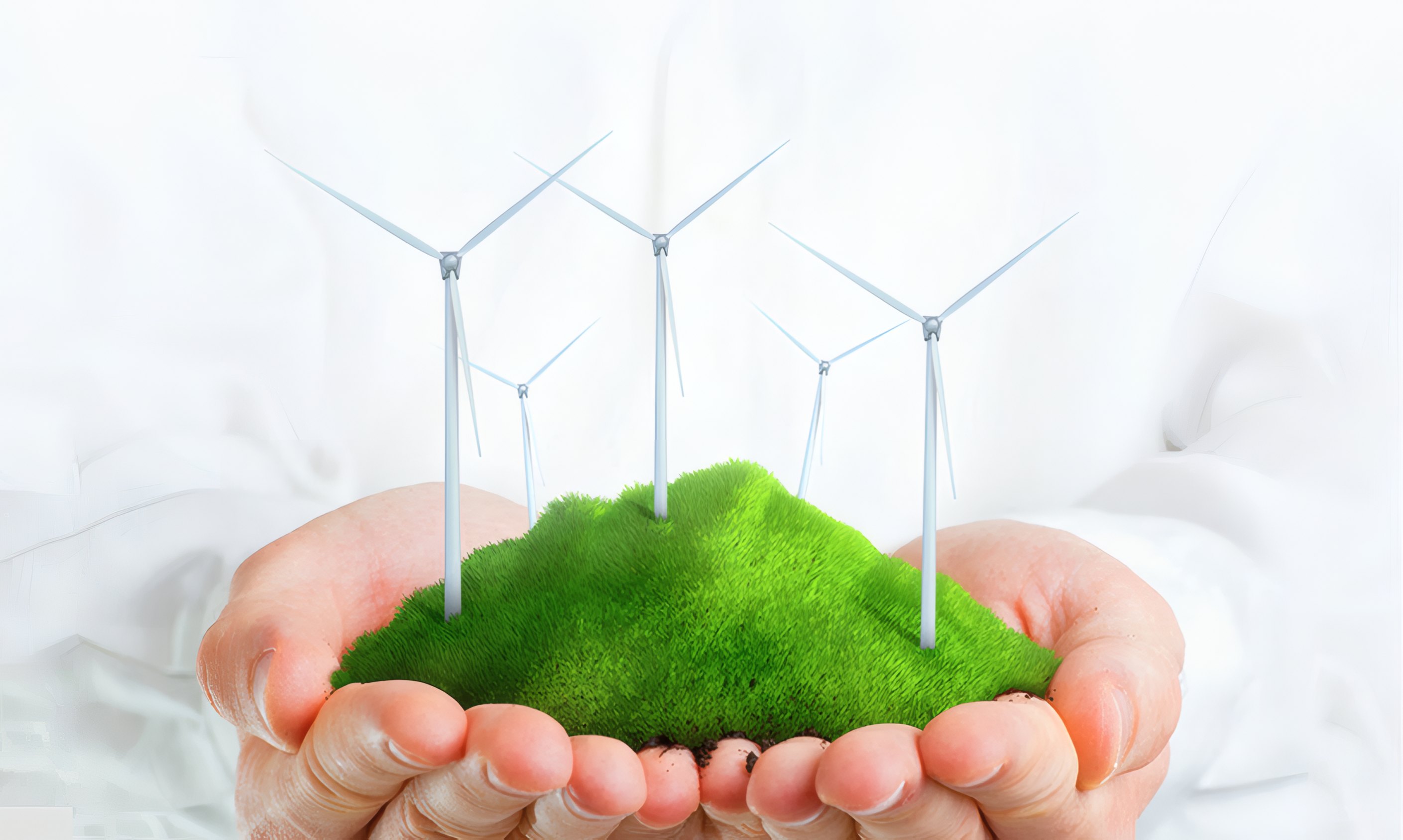 Hands holding a patch of grass with small wind turbines