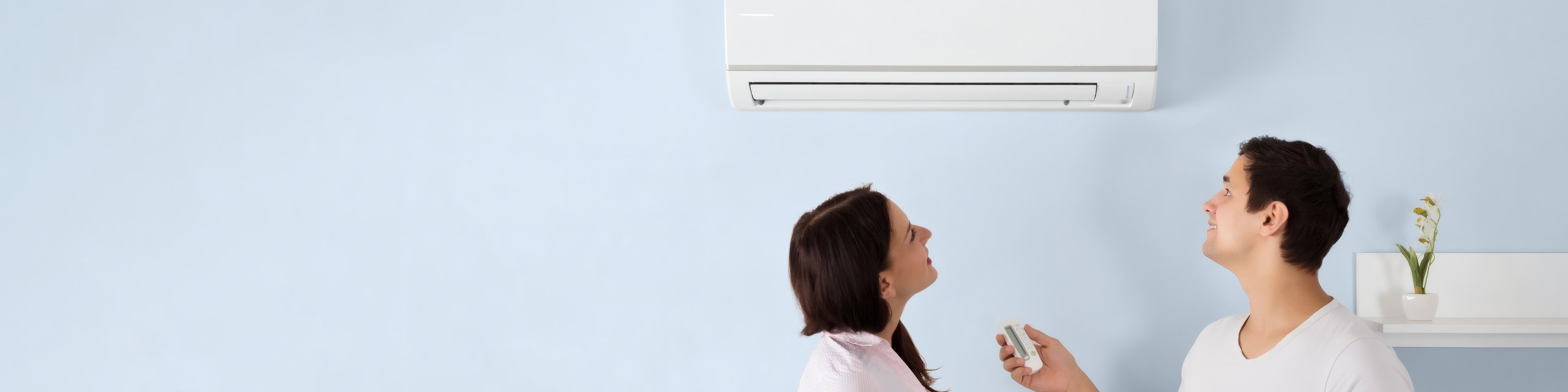 A couple choosing the setting on their new air conditioner