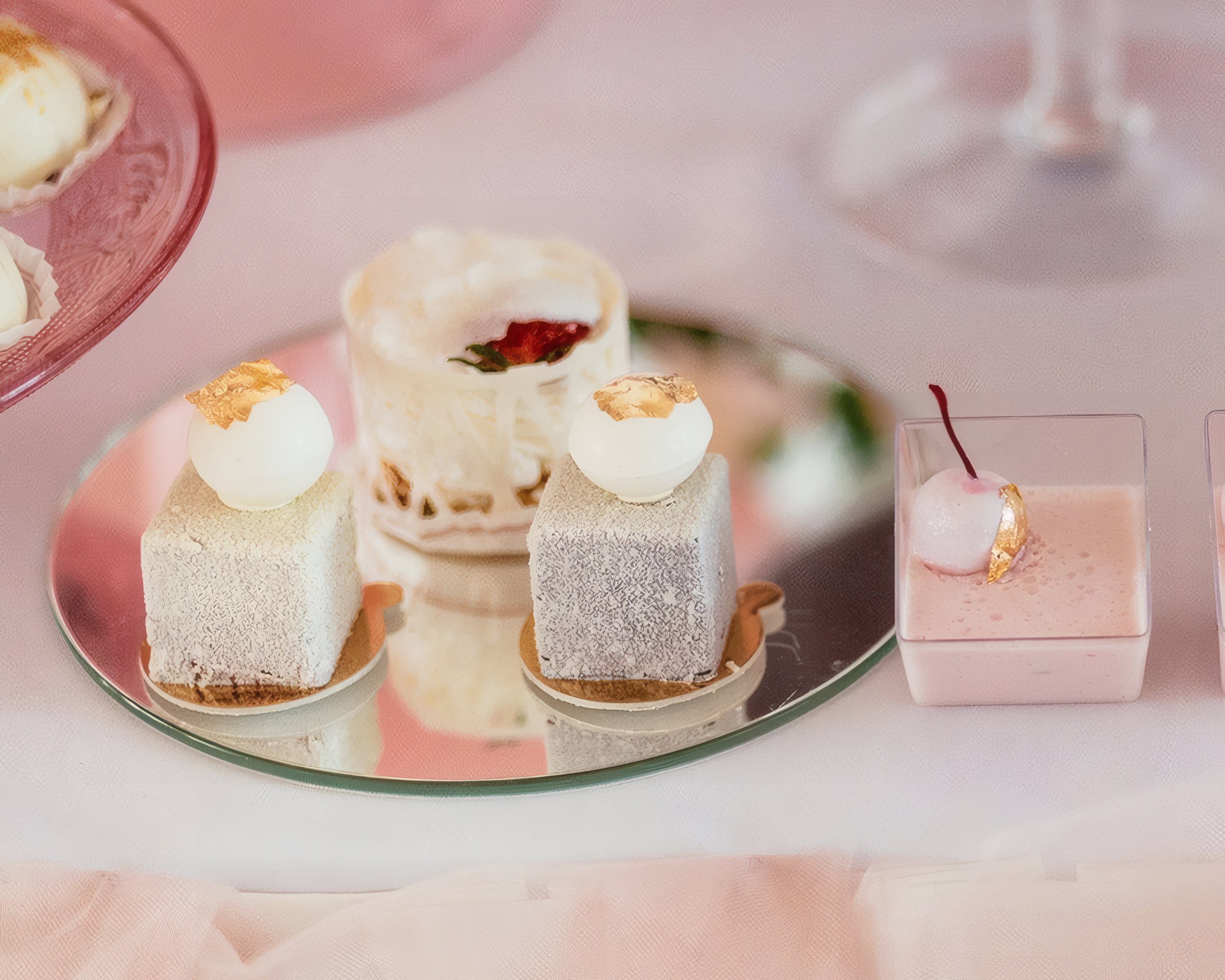 Mini cakes with gold leaf on a mirror tray