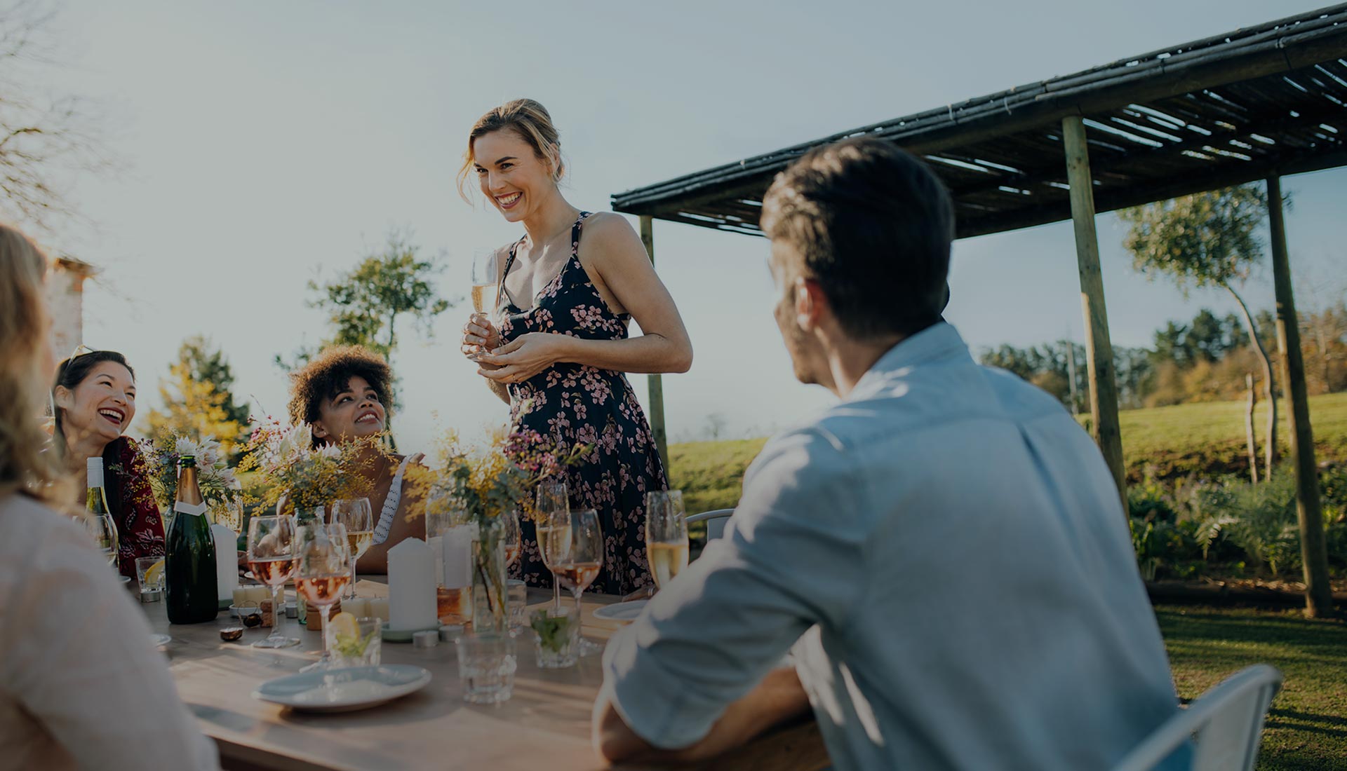Guests toasting at a long table in a summer garden