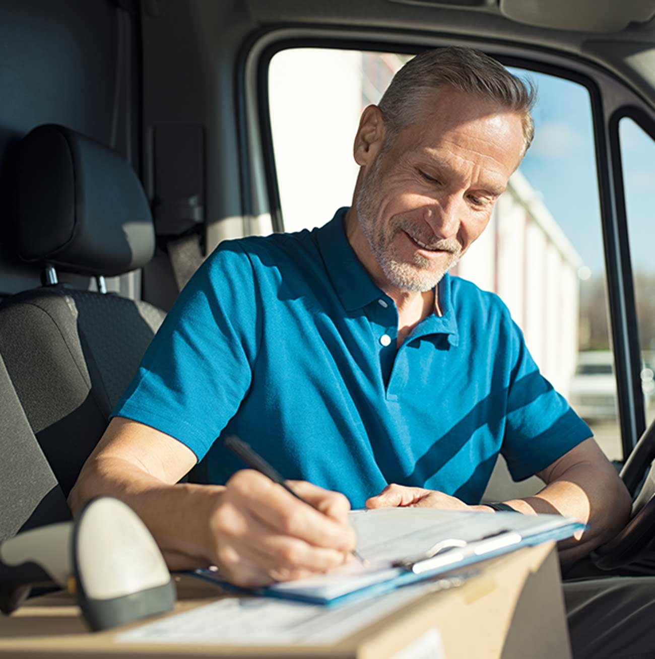 A courier checking an order in his van