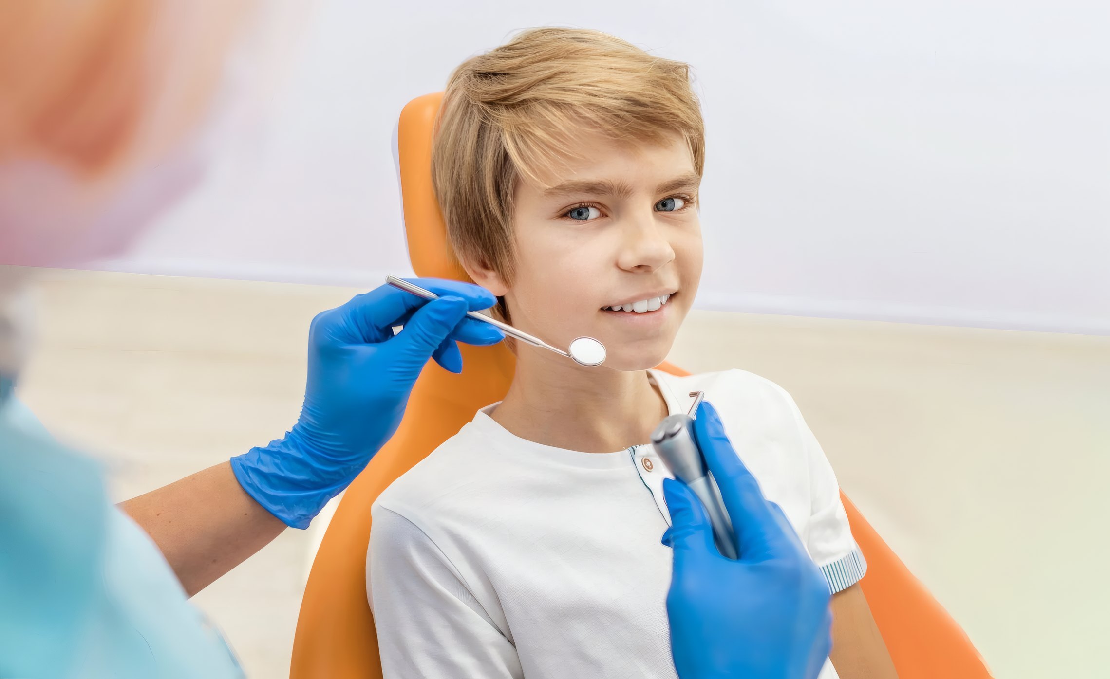 A boy in the dental chair smiling at the dentist
