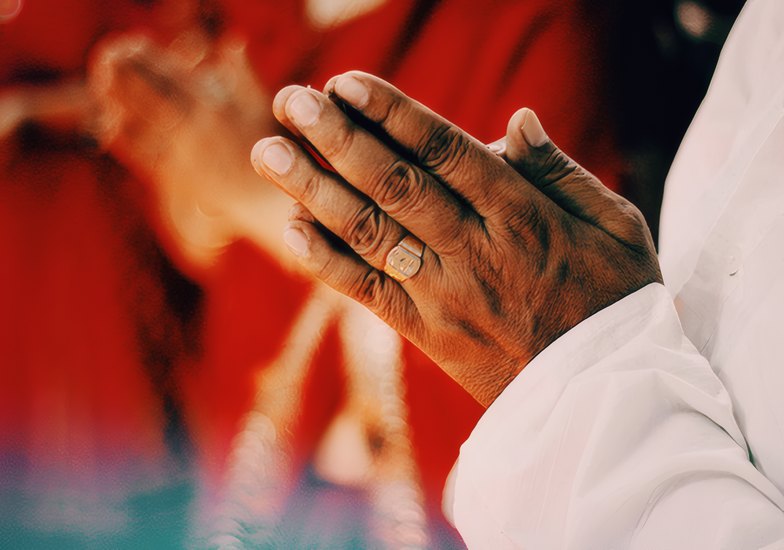 Hands folded in prayer at the offering