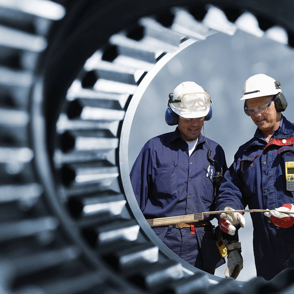 Two engineers inspecting a gear wheel