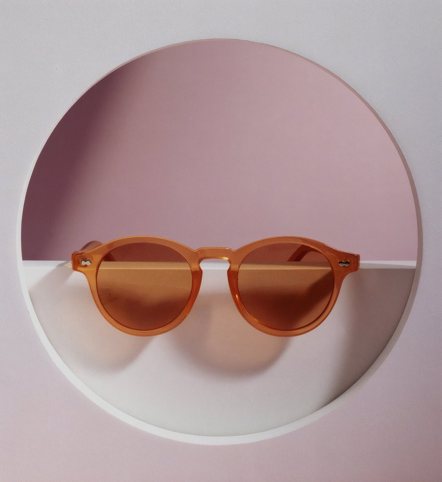 Round tortoiseshell sunglasses in a pink circular niche