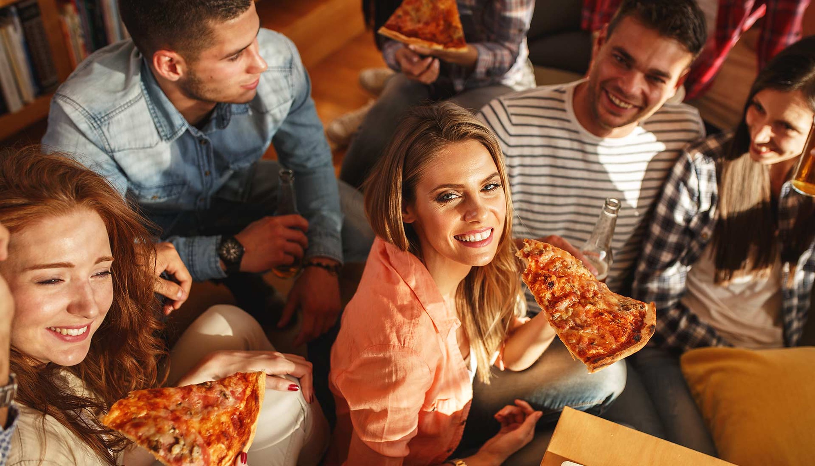 Friends sharing pizza at a long table