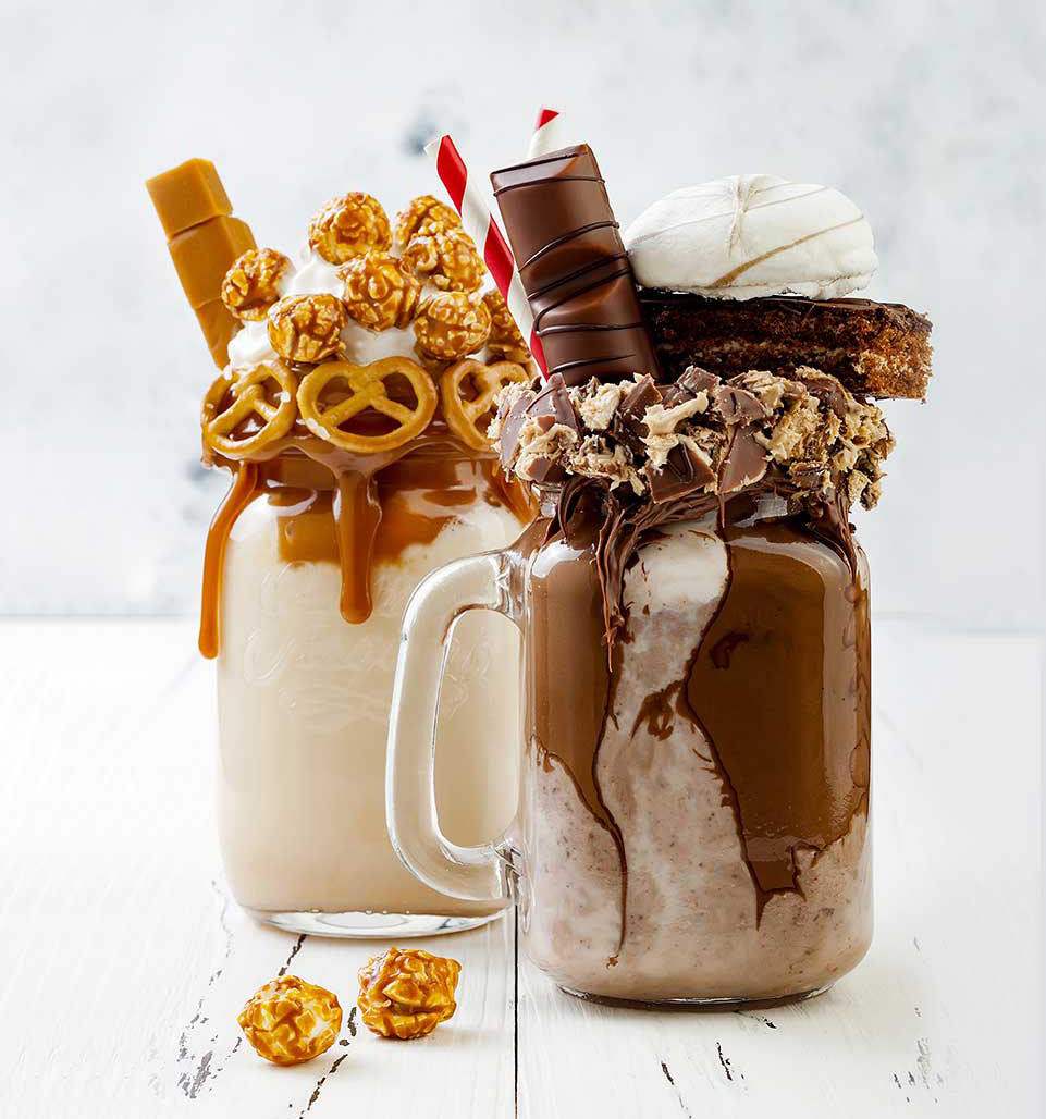 A chocolate freakshake piled with brownie and pretzels