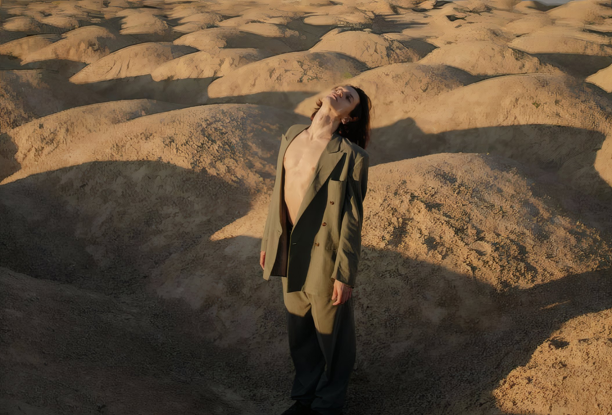 A man in a long coat on the dunes