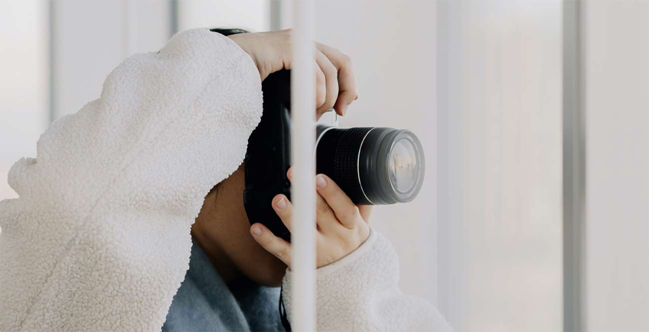 A camera raised to the eye by a bright window