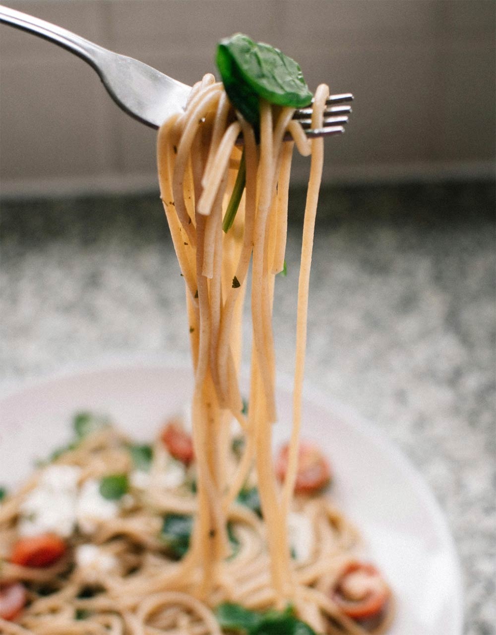 Spaghetti lifted on a fork over the plate