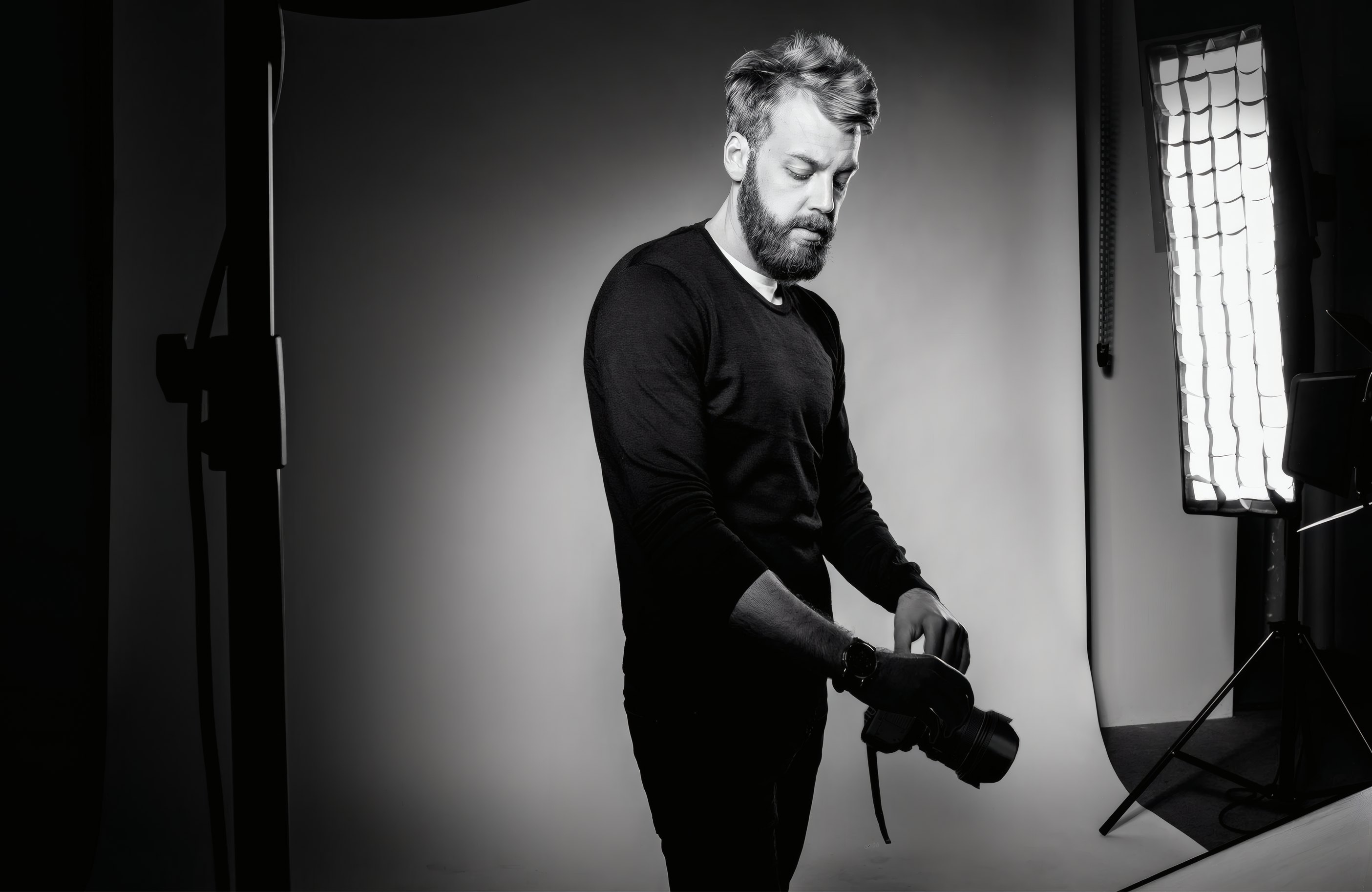 A photographer beside a softbox in the studio