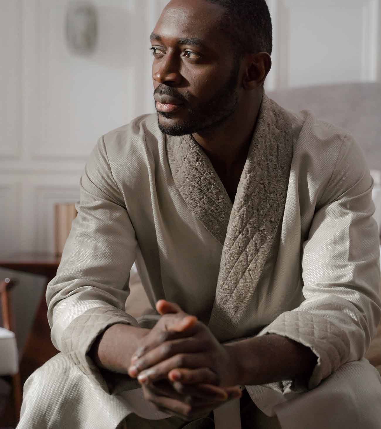 A man in a quilted robe, seated