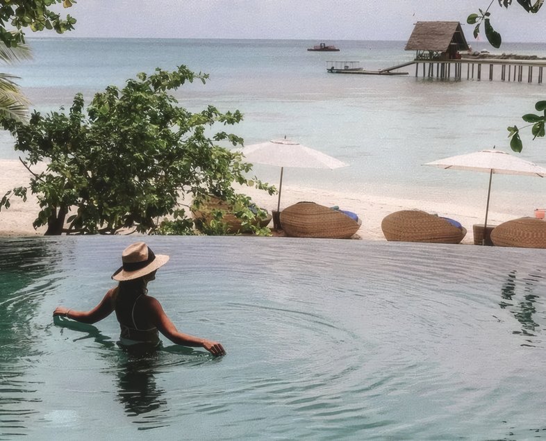 A guest wading in the lagoon pool by the sea