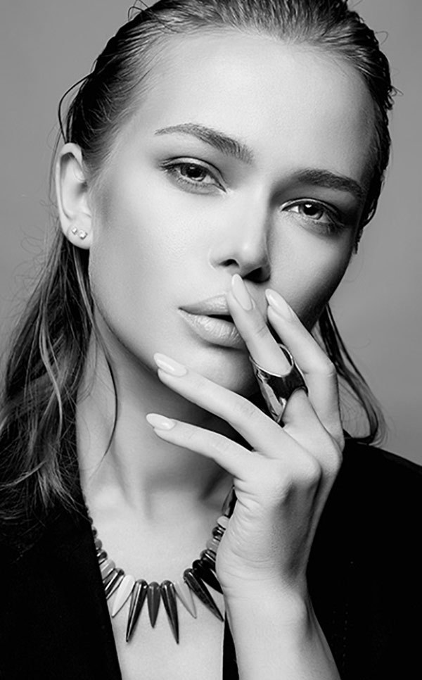 A client in black with a statement necklace, in black and white