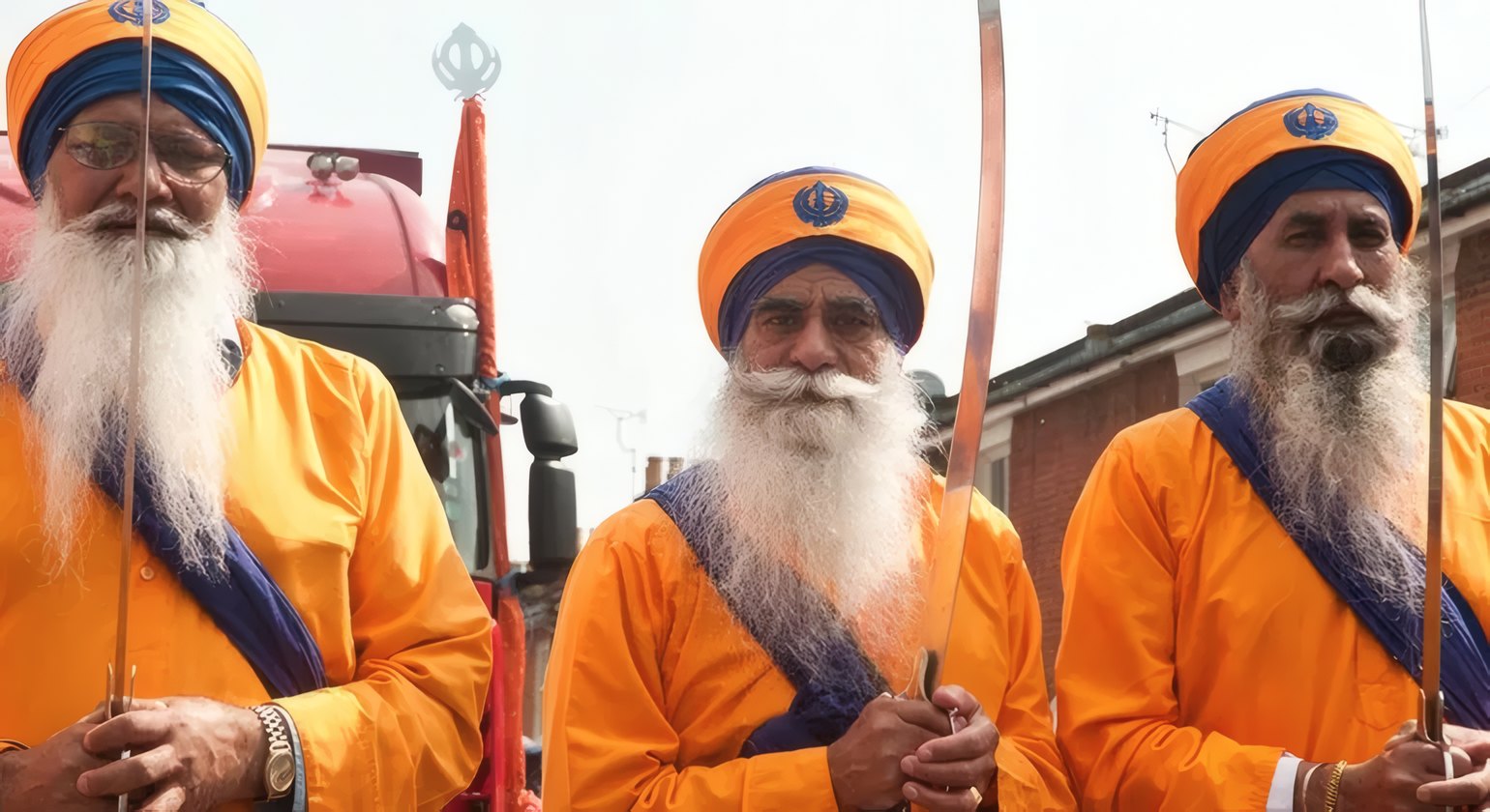Three Nihang Singhs in saffron at the gurdwara