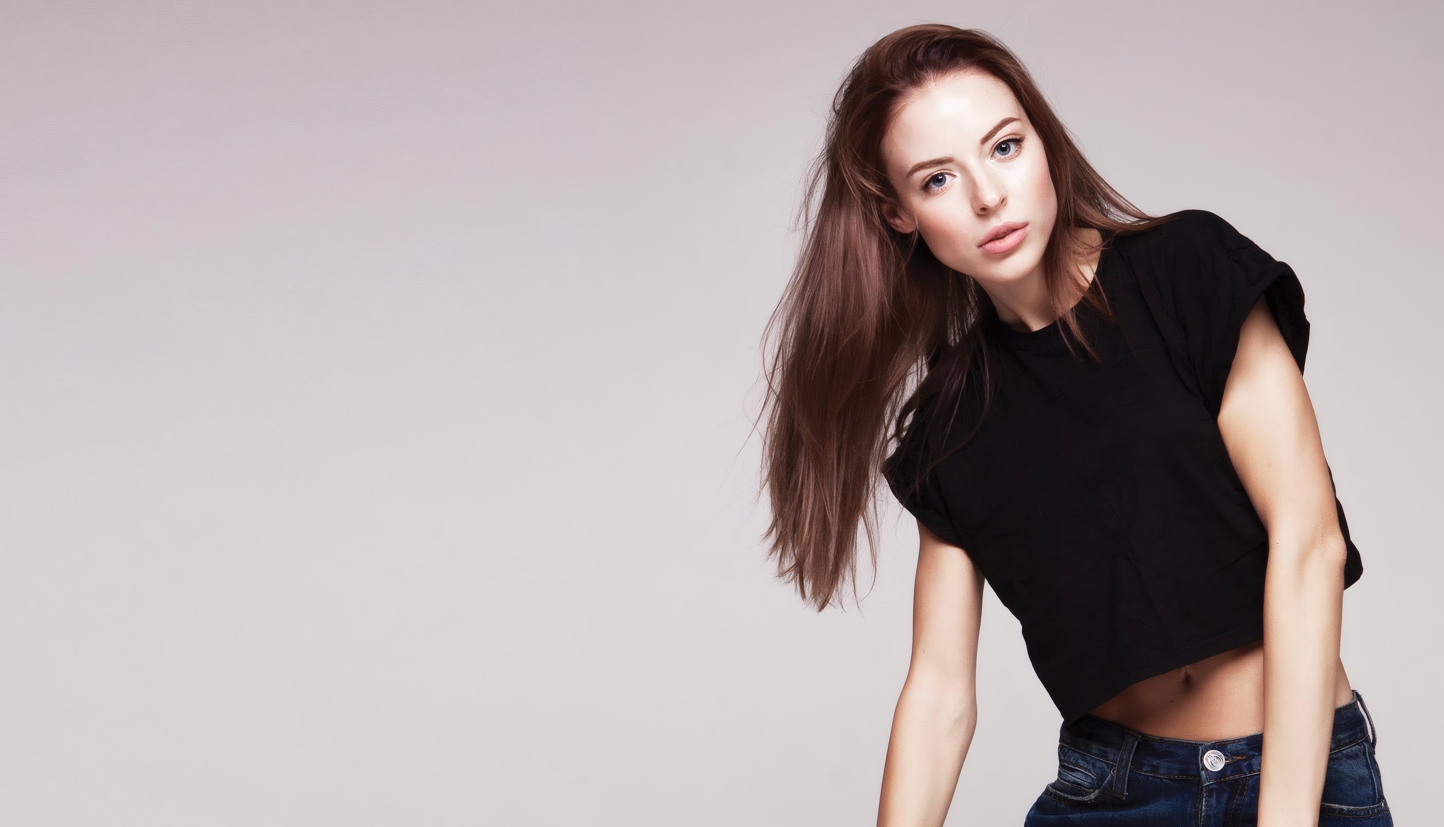 A model in the label's black crop tee and jeans in the studio