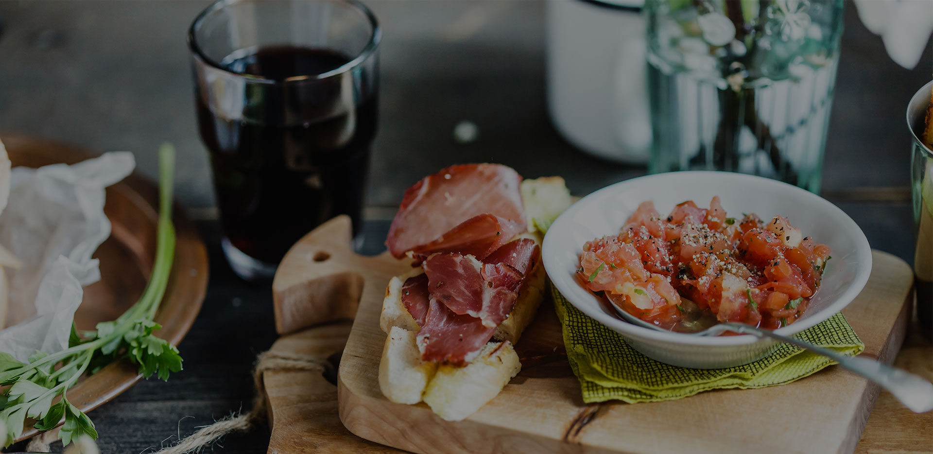 Cured ham, prawns and a glass on a sharing board