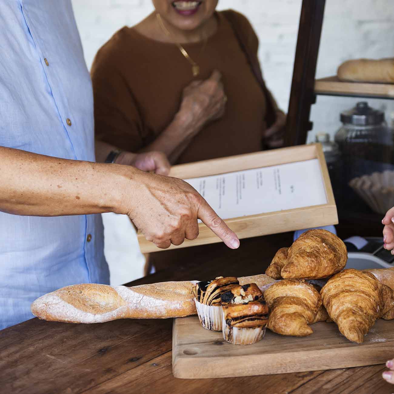 A customer choosing pastries from the menu