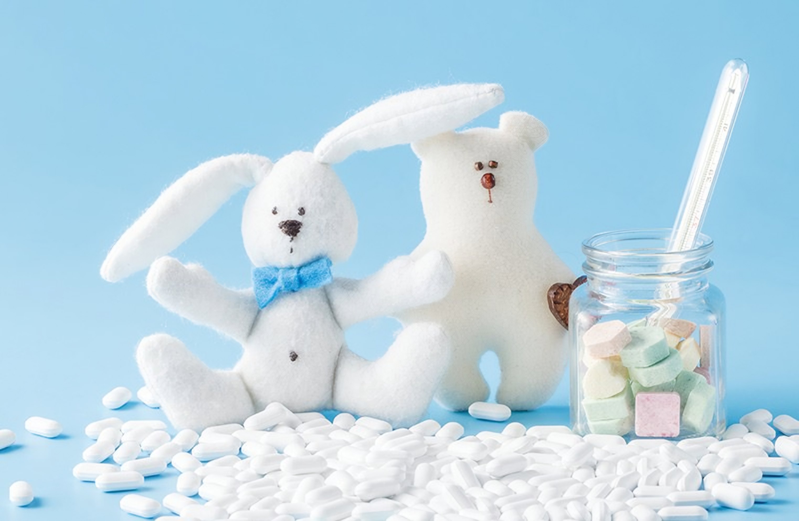 Soft toys and pills on a pale blue shelf
