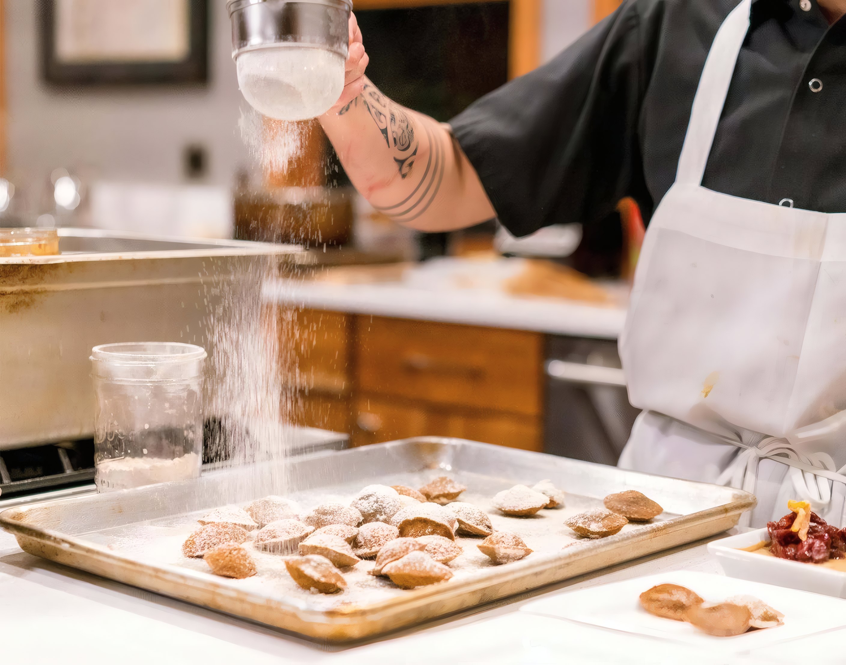 Icing sugar dusted over a tray of cookies