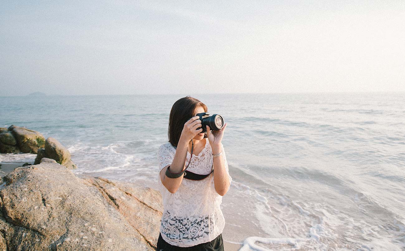 A photographer at the shore with her camera
