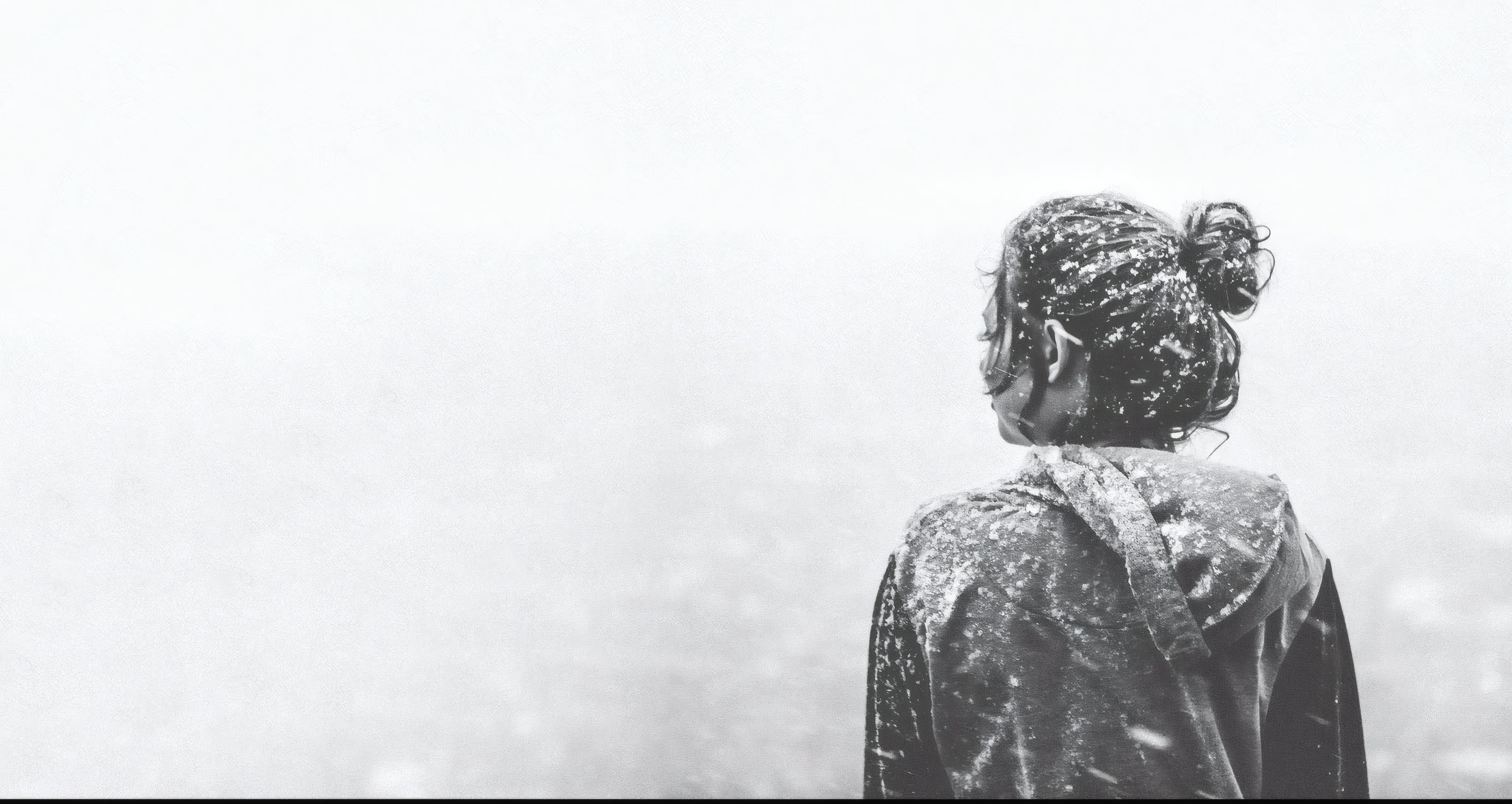 A model in a sequinned coat seen from behind in a white fog