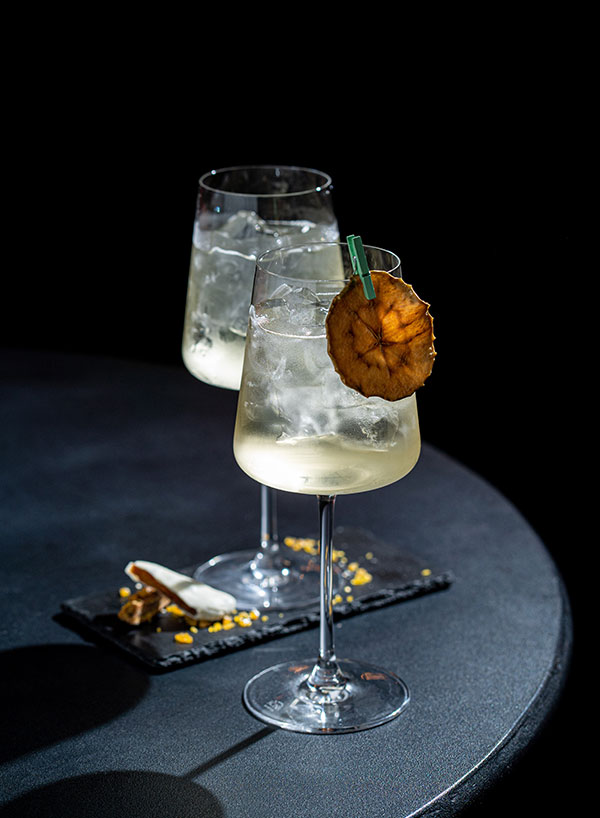 Two cocktails on a dark round table