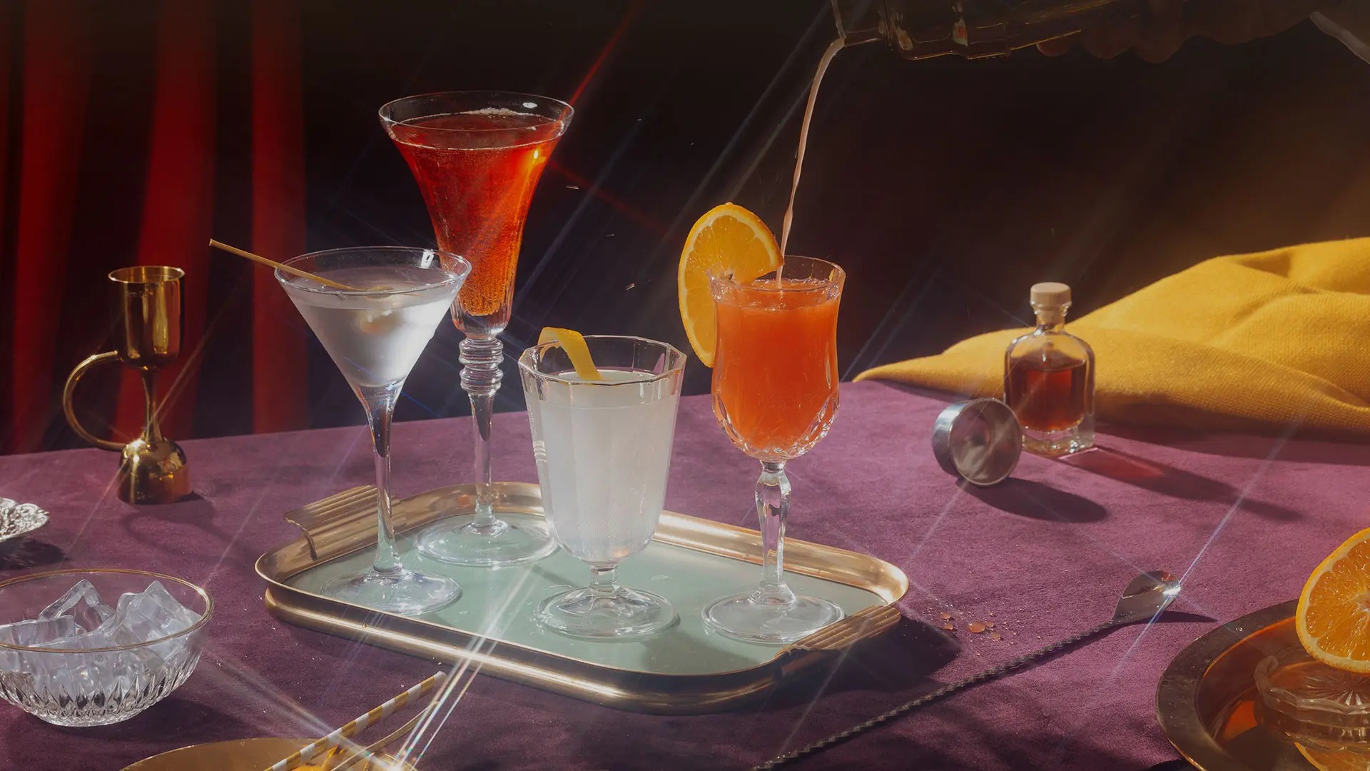 A cocktail poured into a coupe on a velvet table