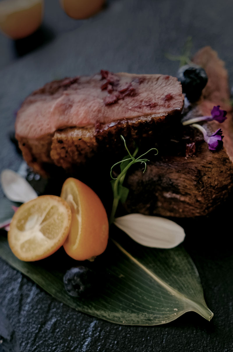 A seared cut with orange and edible flowers