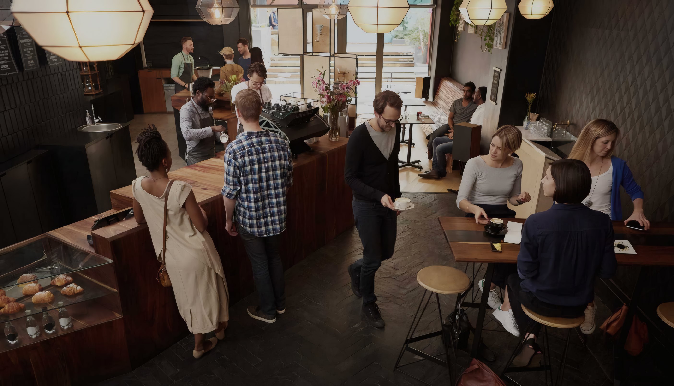 Guests at the counter and the tables of a busy cafe