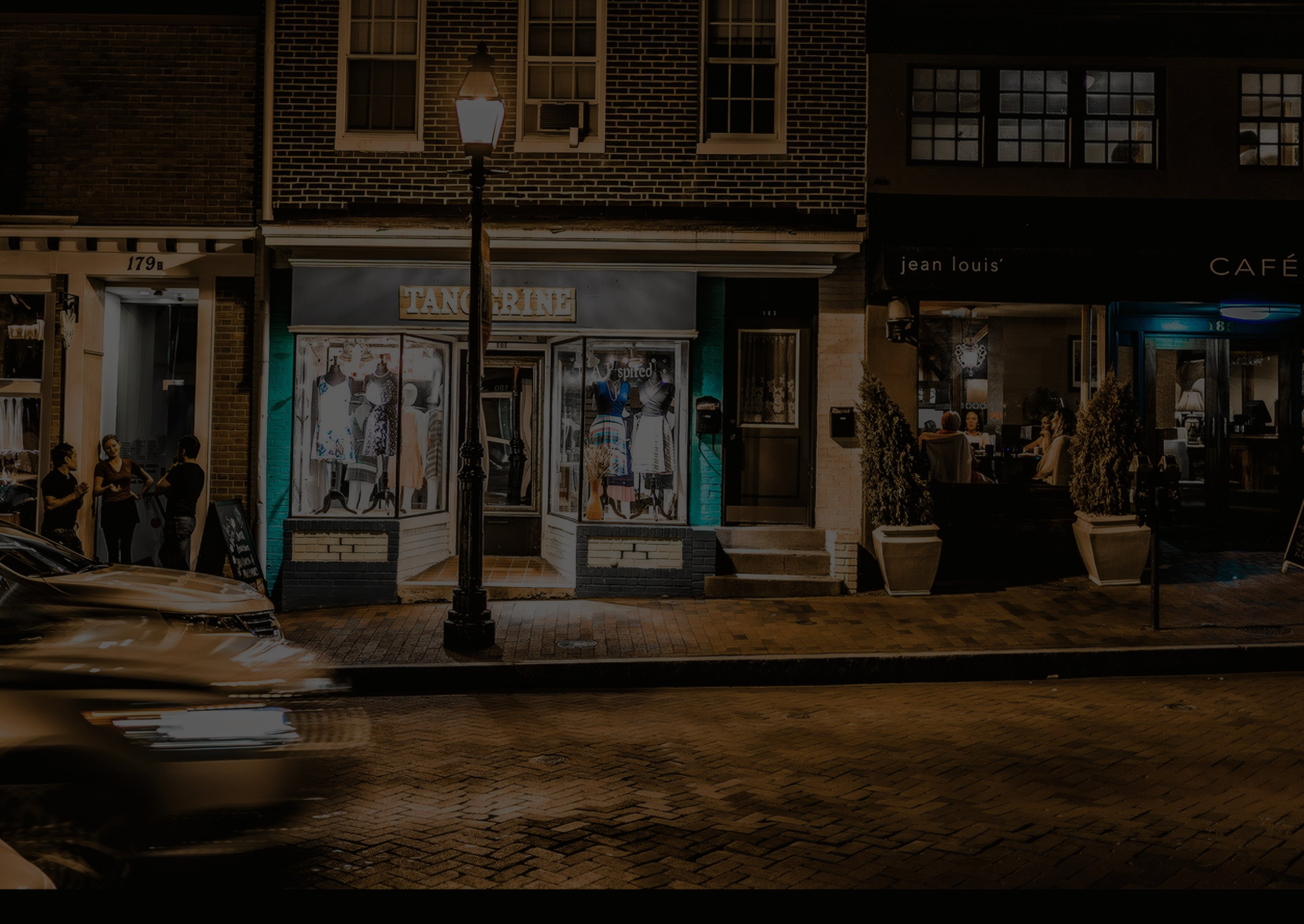 A corner cafe lit up on a quiet evening street