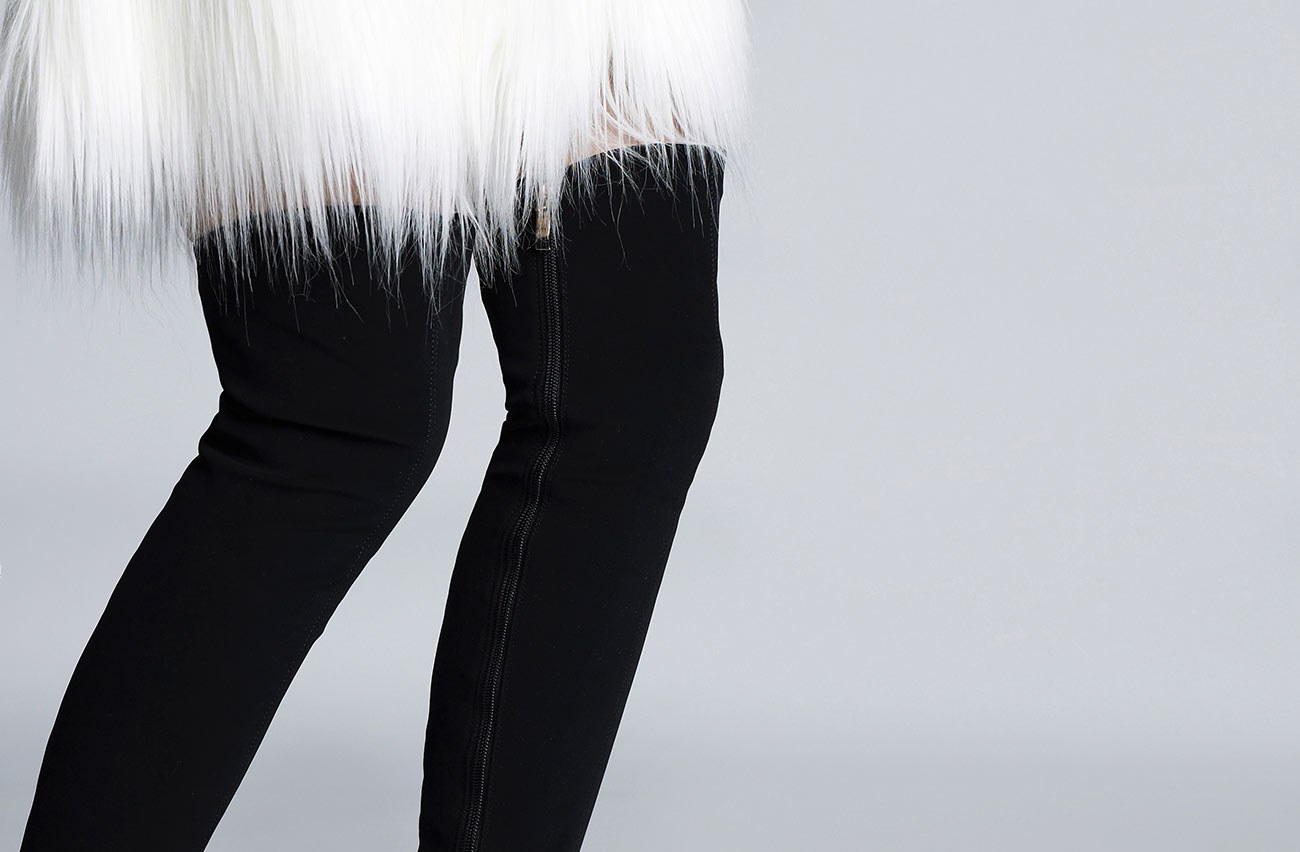 A white fur coat over black trousers