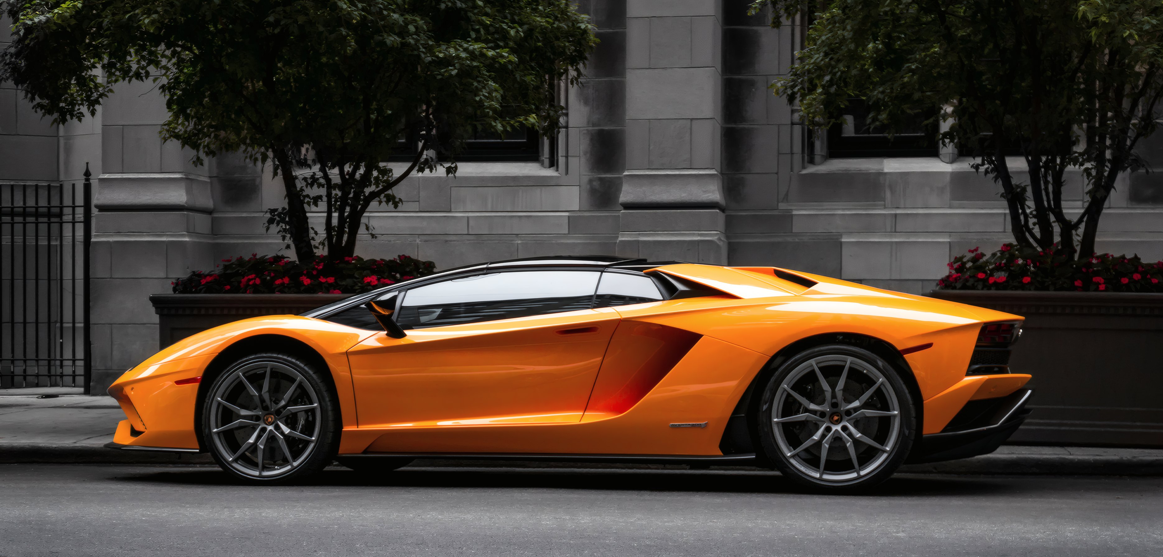 A performance car parked by a city building