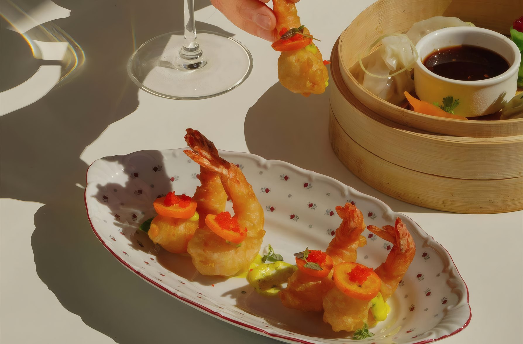 Prawns and dumplings with a dipping sauce in the afternoon sun