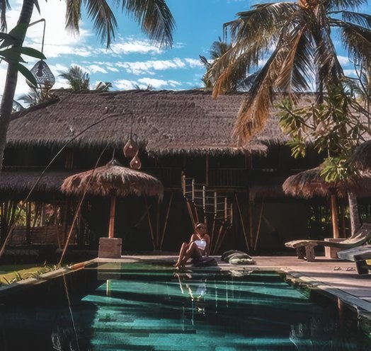 A thatched pool villa at dusk