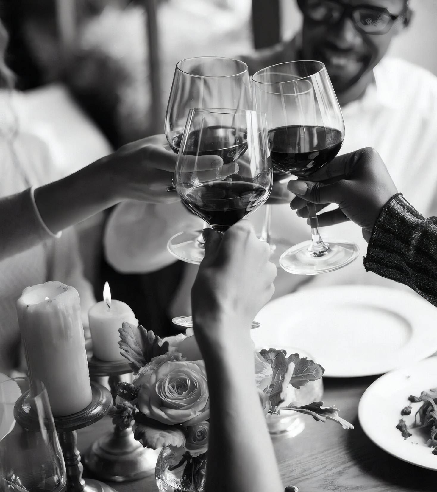 Guests touching glasses of red wine across the table