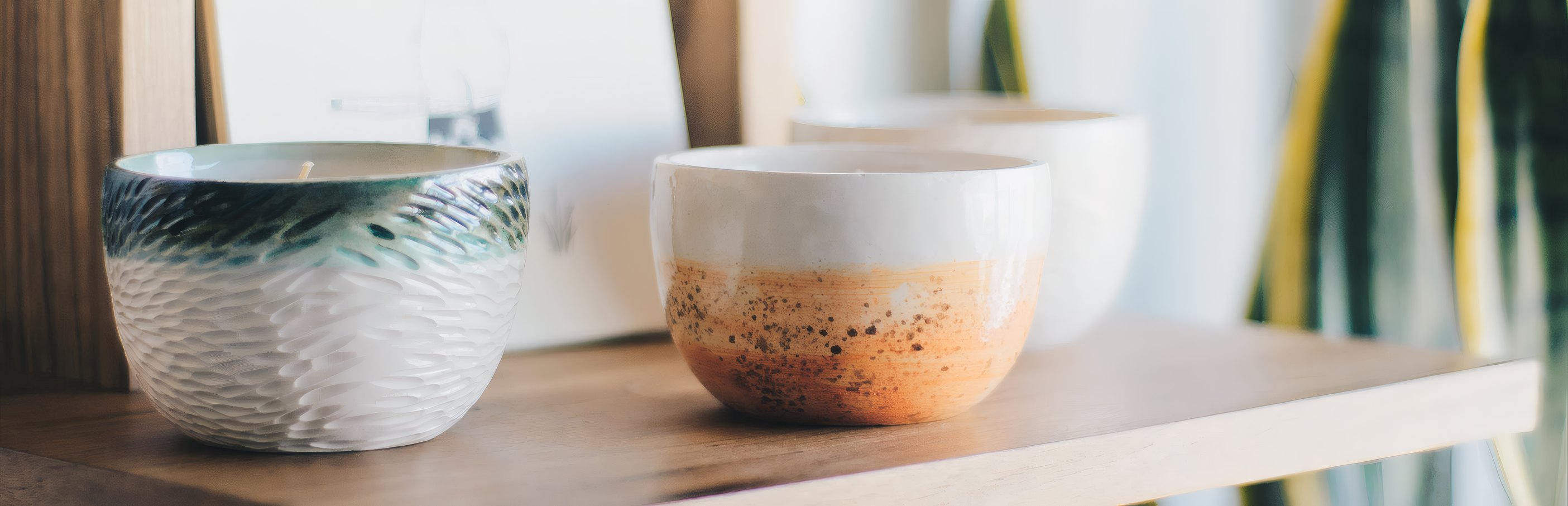 Two glazed tea bowls on a wooden shelf