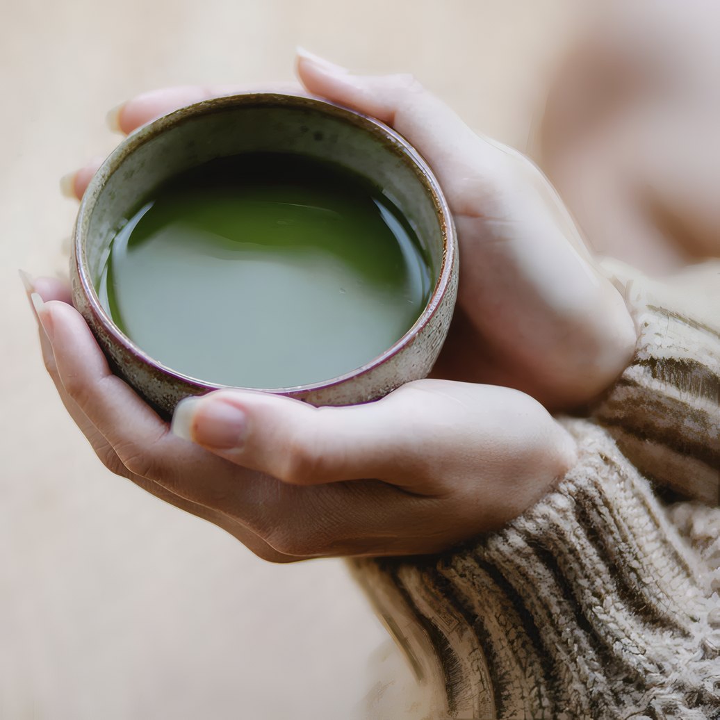 A bowl of whisked matcha held in two hands