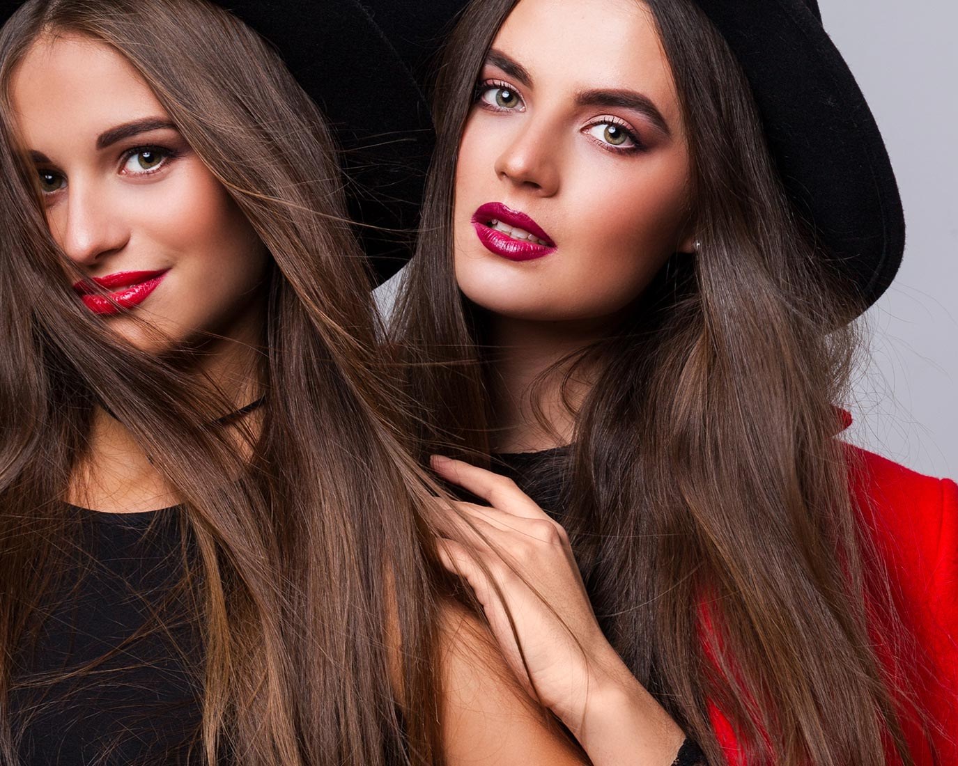 Two new faces in black hats and red lipstick