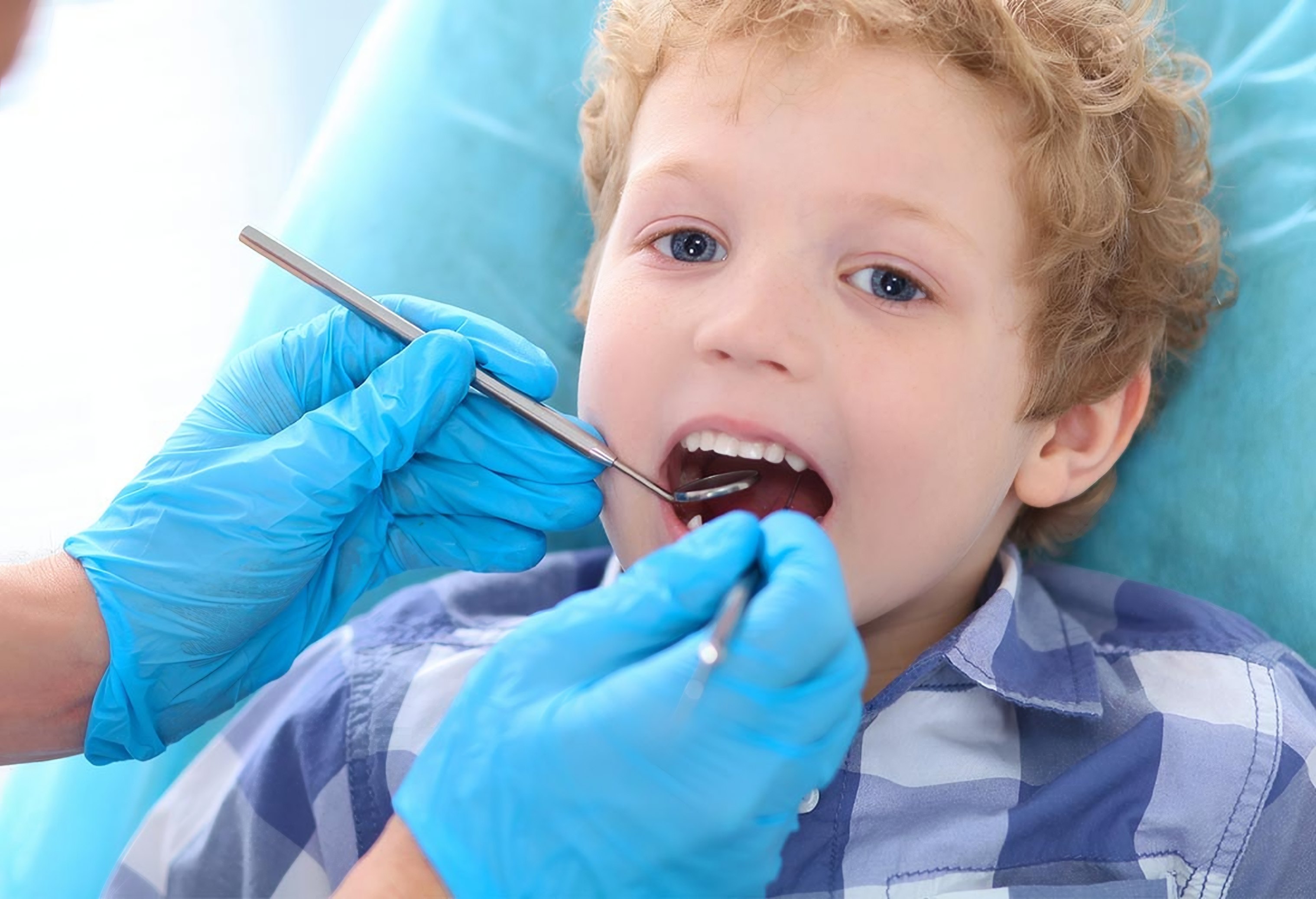 A boy has his teeth checked by a dentist