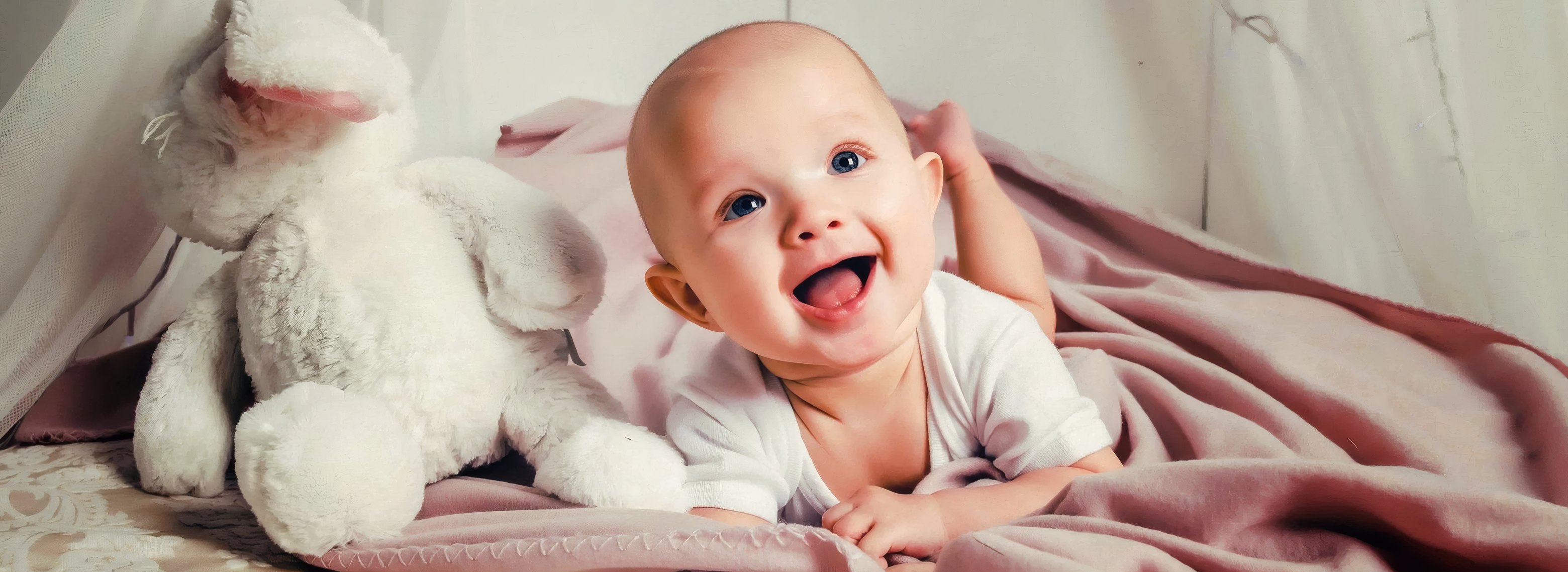 Smiling baby among soft toys