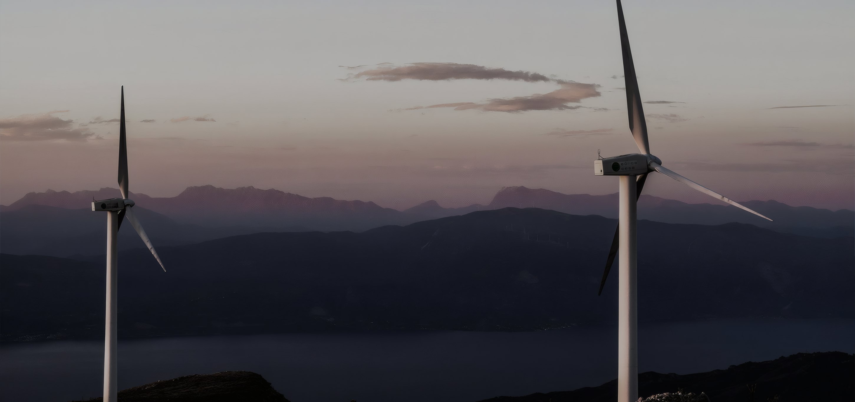 Wind turbines against the mountains at dusk