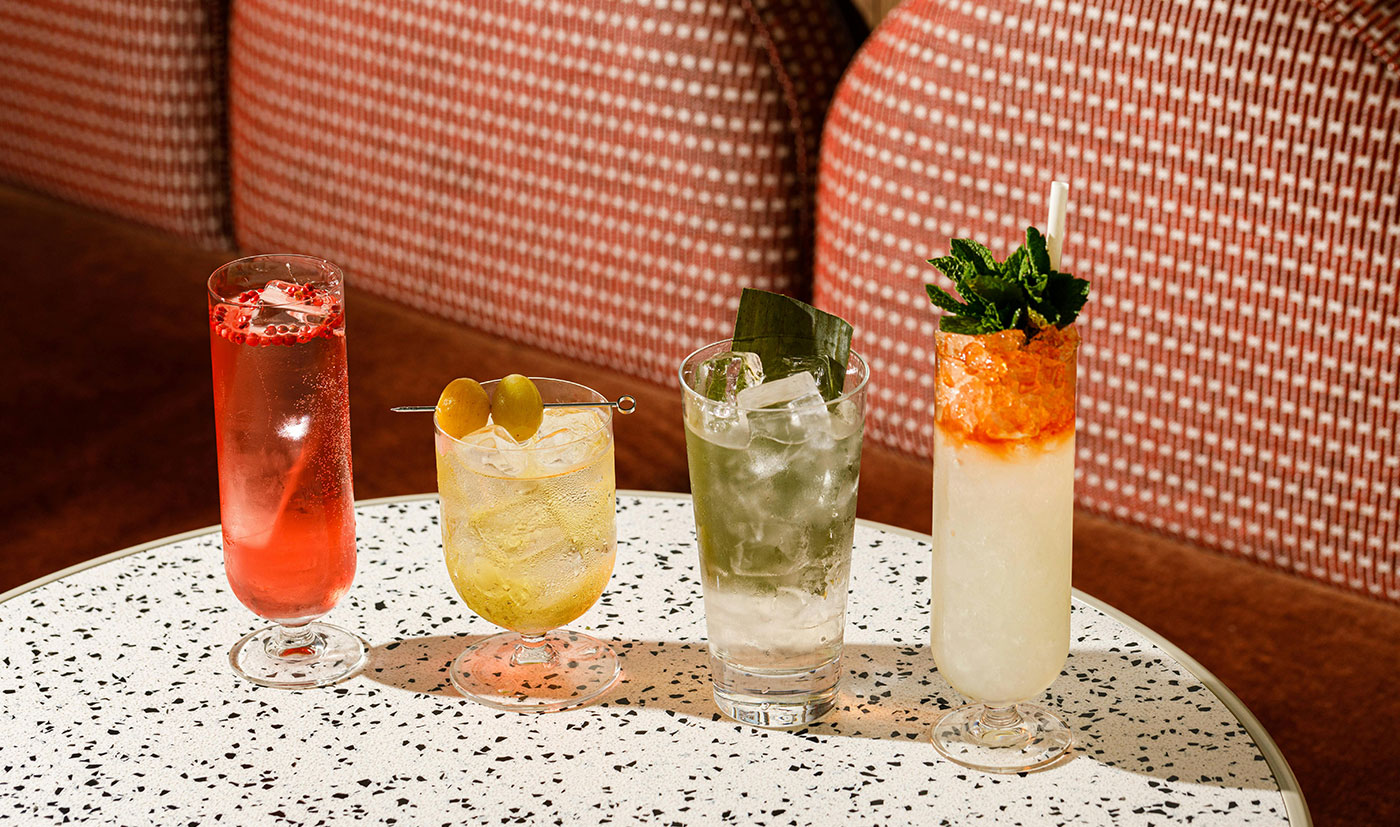 Four colourful highballs on a terrazzo table